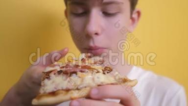 披萨。 快乐的青少年男孩吃一片披萨的概念。 十几岁的男孩饿了吃一片披萨。 慢速视频